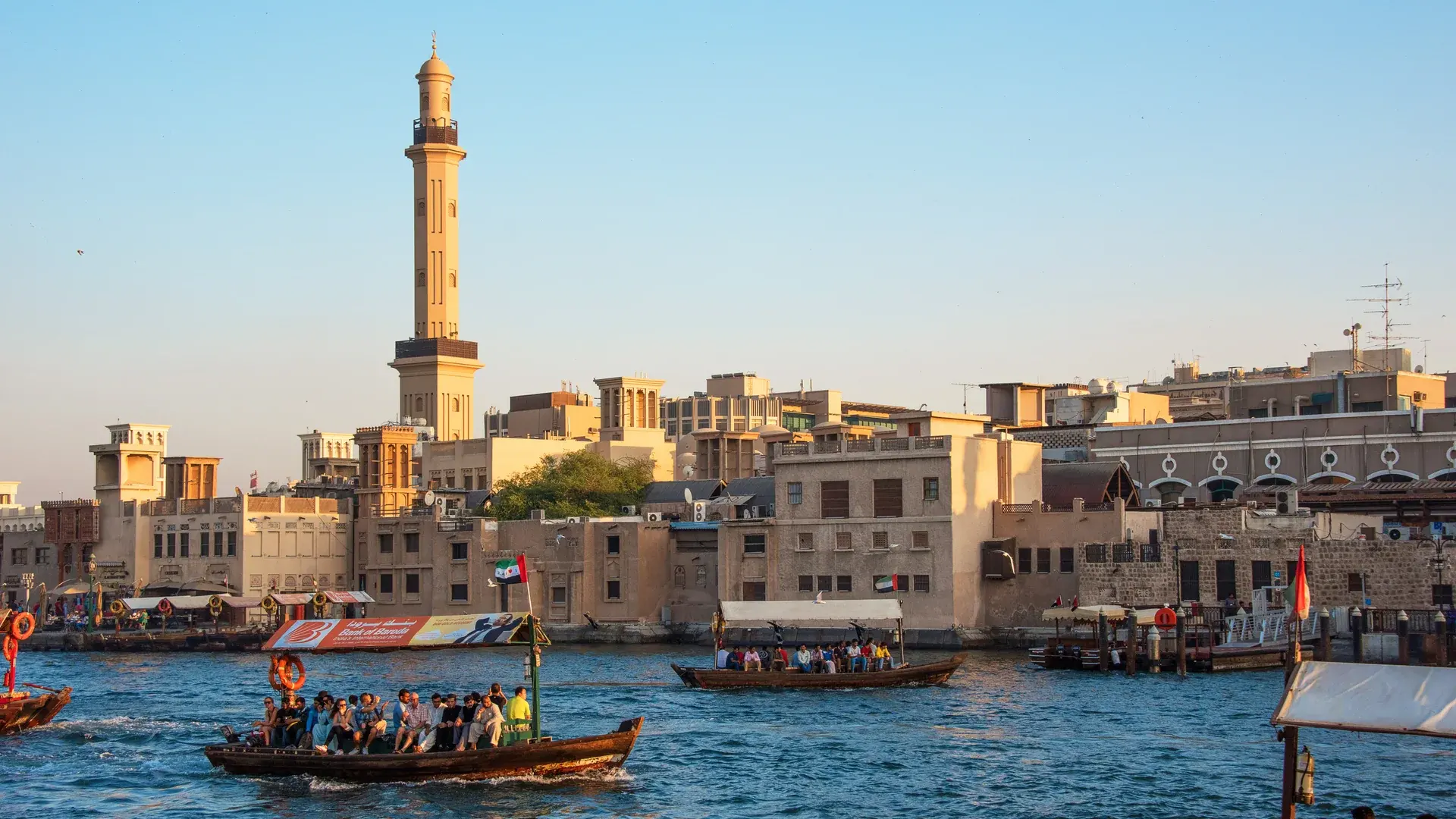 Dubai Creek kıyısındaki yapılar ve geleneksel abra teknesi